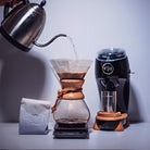 Black Niche Zero next to goose neck kettle pouring water into chemex