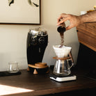 Black Niche Duo with grind cup pouring ground coffee into v60