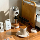 White Niche Zero next to espresso machine with freshly made coffee in front
