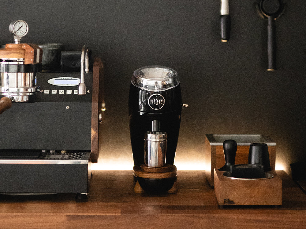 Black Niche Zero next to espresso machine